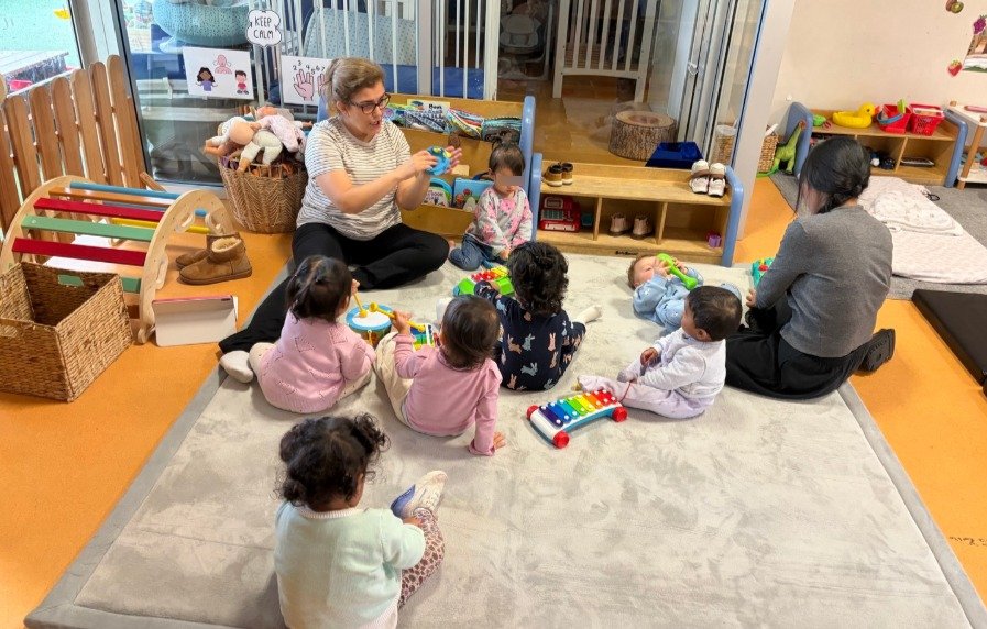 infants in childcare with musical toys