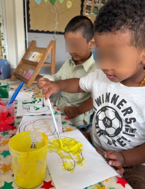 toddlers painting in cocoon club childcare room
