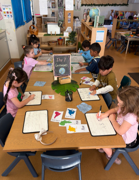 preschoolers writing at a table at kiddie garden parramatta