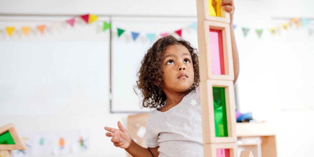 preschool child stacking blocks high