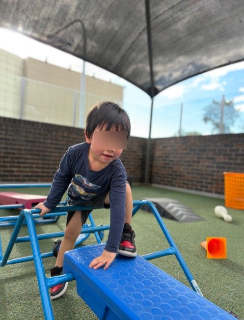 preschool child climbing on small frame at our parramatta childcare centre