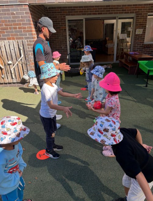 preschool children playing outdoors with soft footballs